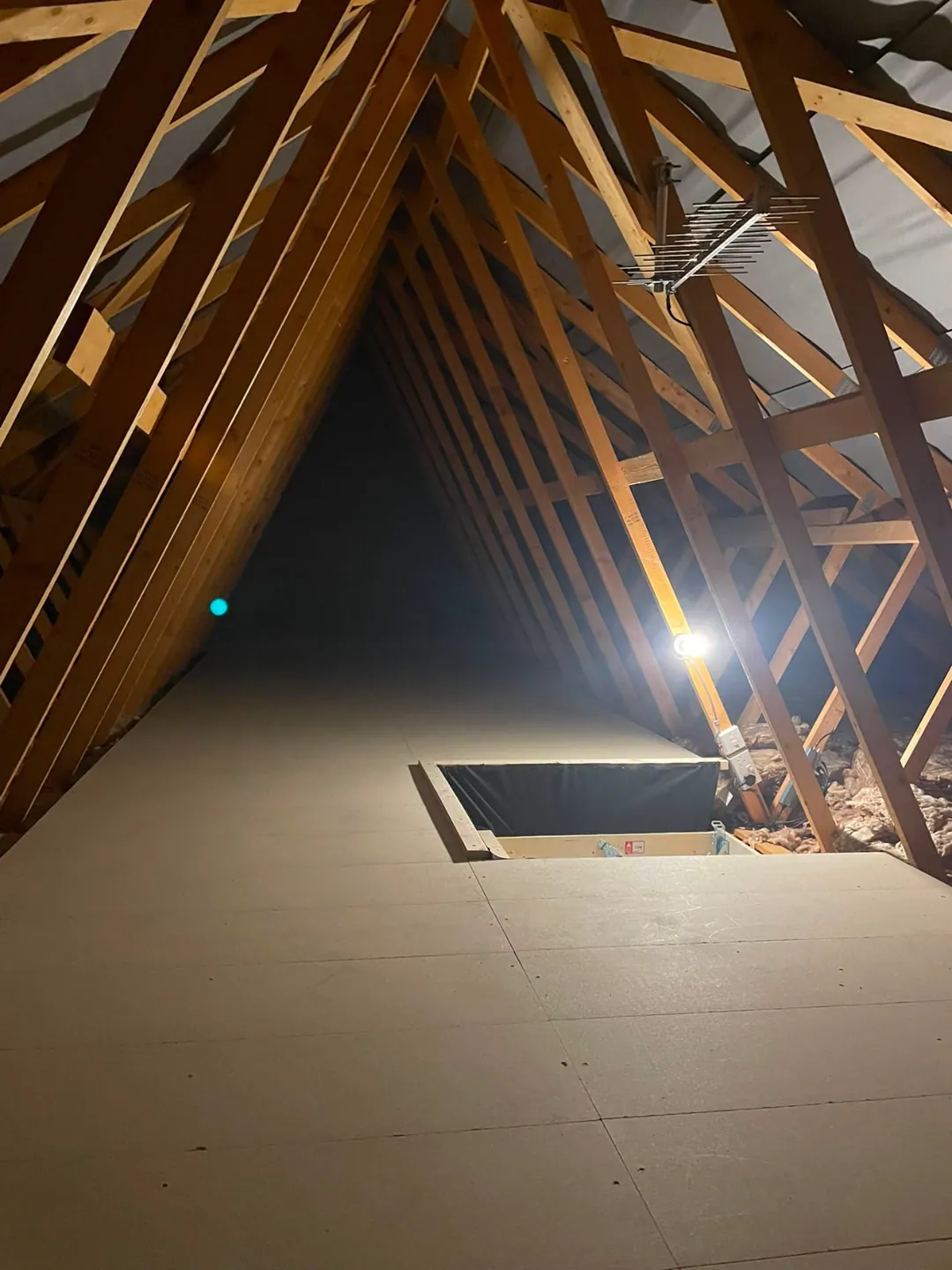 Client-supplied photograph of loft boards fitted around a loft hatch